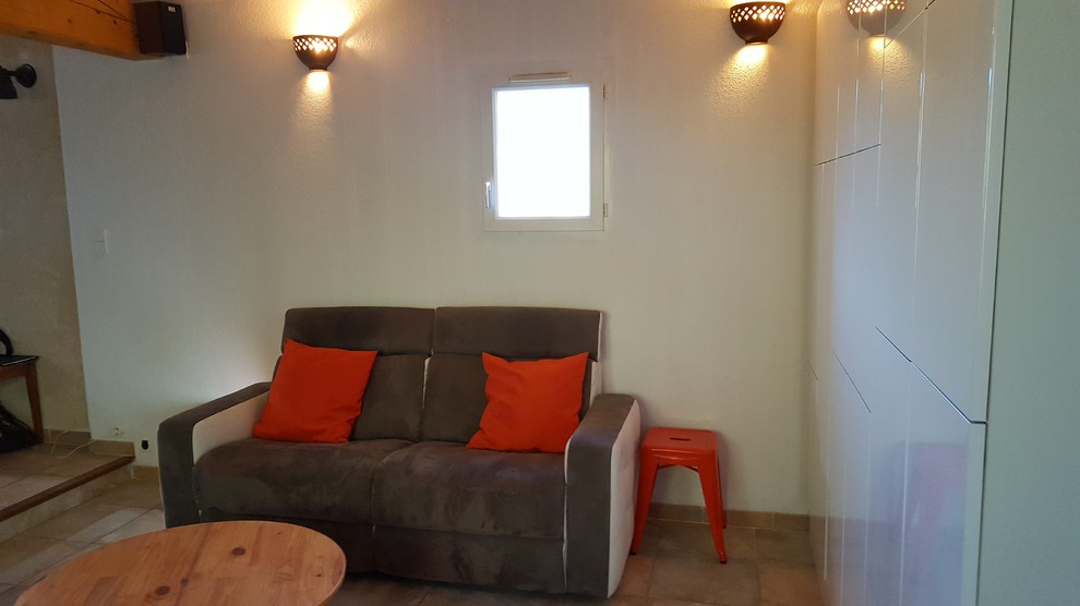 Стильный дизайн: маленькая двухуровневая гостиная комната в восточном стиле с белыми стенами, полом из керамической плитки, телевизором на стене и бежевым полом без камина для на участке и в саду - последний тренд
