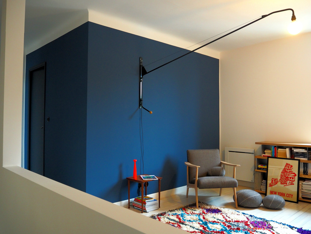 Стильный дизайн: двухуровневая гостиная комната среднего размера в современном стиле с с книжными шкафами и полками, синими стенами и деревянным полом без камина, телевизора - последний тренд
