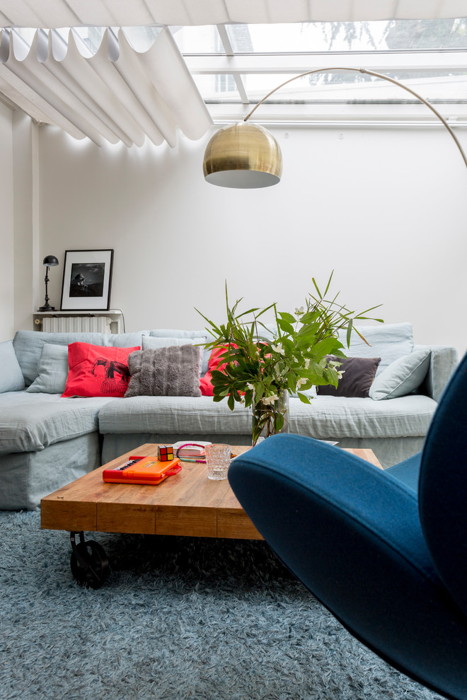 Réalisation d'un salon design avec une salle de réception, un mur blanc, un sol bleu et éclairage.