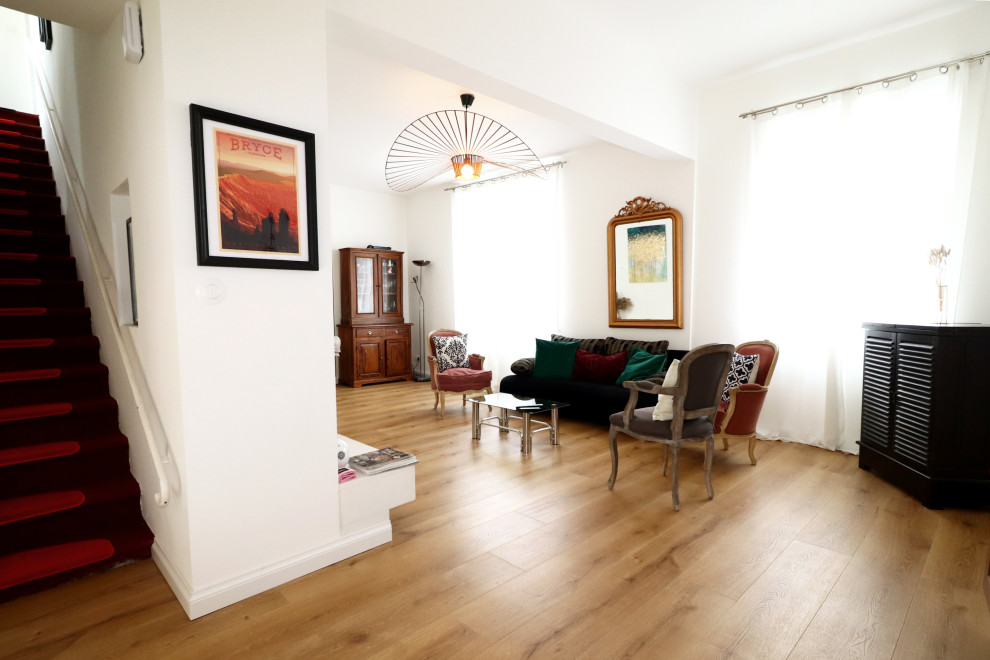 Inspiration pour un grand salon minimaliste ouvert avec un bar de salon, un mur blanc, un sol en bois brun, un poêle à bois, un manteau de cheminée en plâtre, un téléviseur indépendant et un sol beige.