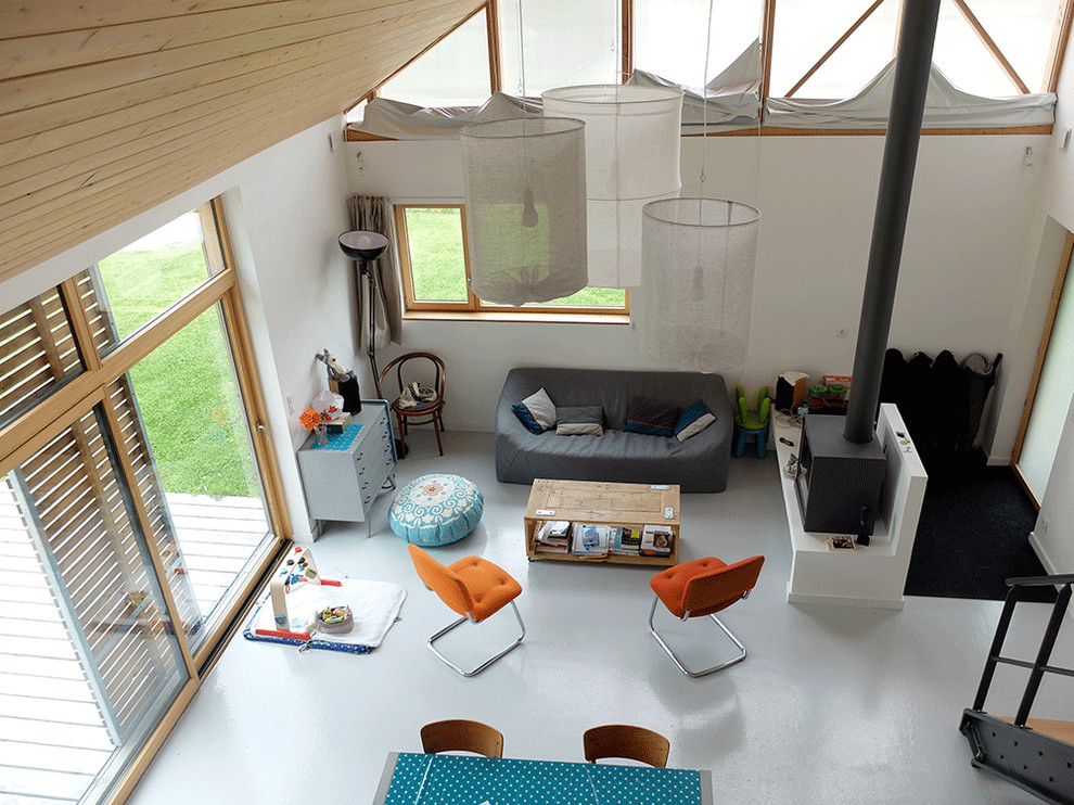 Inspiration för mellanstora moderna loftrum, med vita väggar, betonggolv, en öppen vedspis och grått golv