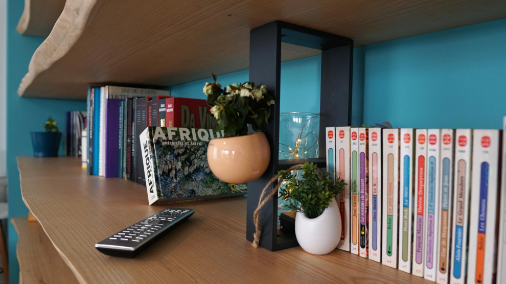 Foto på ett mellanstort skandinaviskt separat vardagsrum, med ett bibliotek, blå väggar, mörkt trägolv och en fristående TV
