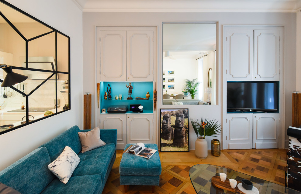 Cette photo montre un salon tendance avec un mur blanc, un téléviseur encastré, parquet clair et un sol beige.