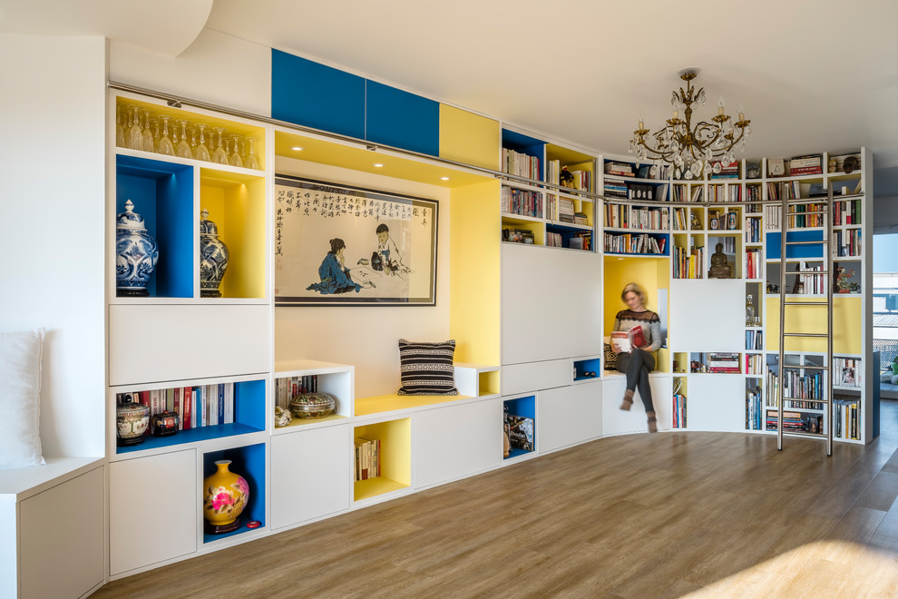 Große, Offene Asiatische Bibliothek ohne Kamin mit weißer Wandfarbe, braunem Holzboden und verstecktem TV in Dijon