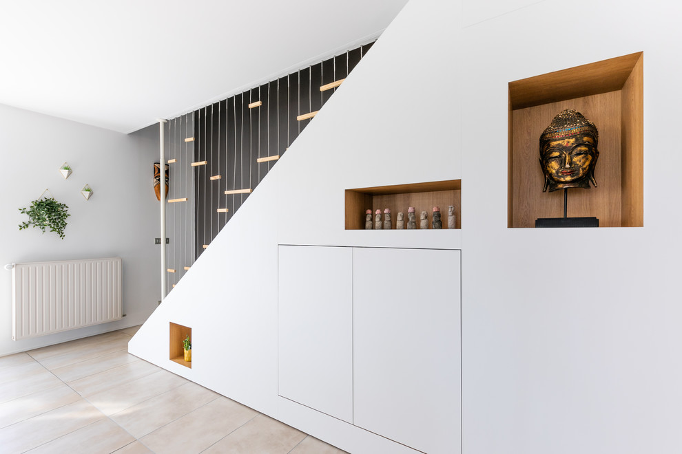 Réalisation d'un grand salon design ouvert avec une salle de réception, un mur gris, un sol en carrelage de céramique et un sol beige.