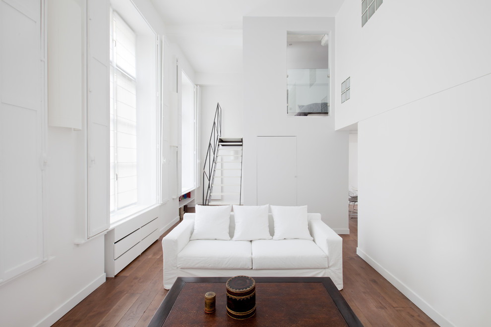 Kleines, Repräsentatives, Fernseherloses, Offenes Modernes Wohnzimmer ohne Kamin mit weißer Wandfarbe und braunem Holzboden in Paris