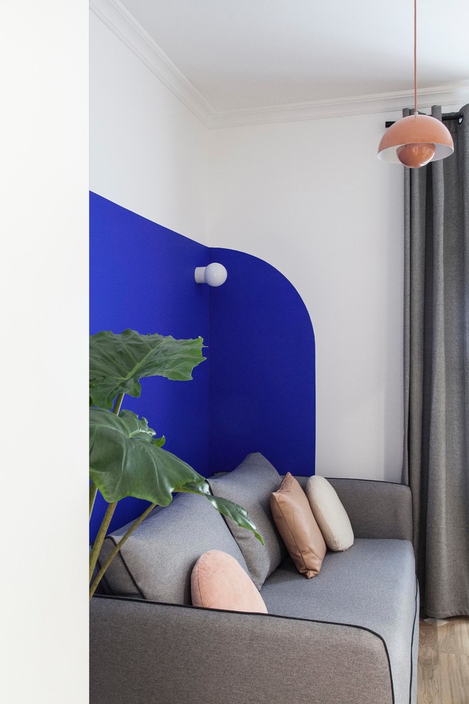 Kleines, Offenes Modernes Wohnzimmer mit blauer Wandfarbe, hellem Holzboden und beigem Boden in Paris