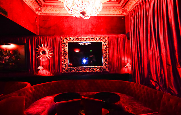 Modelo de cine en casa cerrado clásico de tamaño medio con paredes rojas, moqueta y suelo negro
