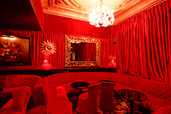 Réalisation d'un salon tradition de taille moyenne et fermé avec un bar de salon, un mur rouge, moquette, aucune cheminée, un téléviseur dissimulé et un sol noir.
