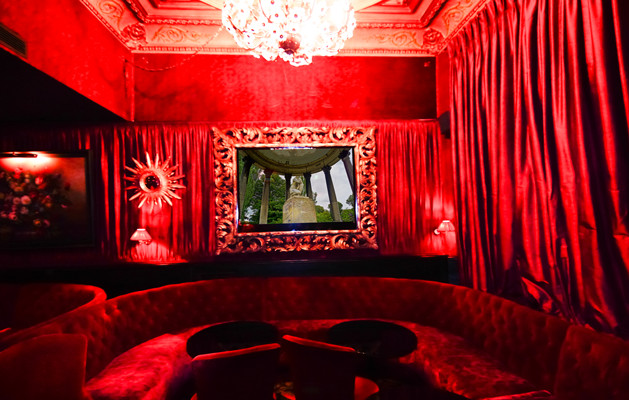 Esempio di un soggiorno minimal di medie dimensioni e chiuso con angolo bar, pareti rosse, moquette, nessun camino, TV nascosta e pavimento nero