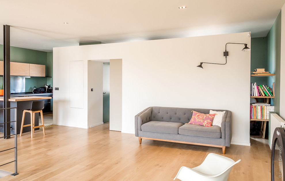 Imagen de salón abierto tradicional renovado grande con paredes verdes y suelo de madera clara