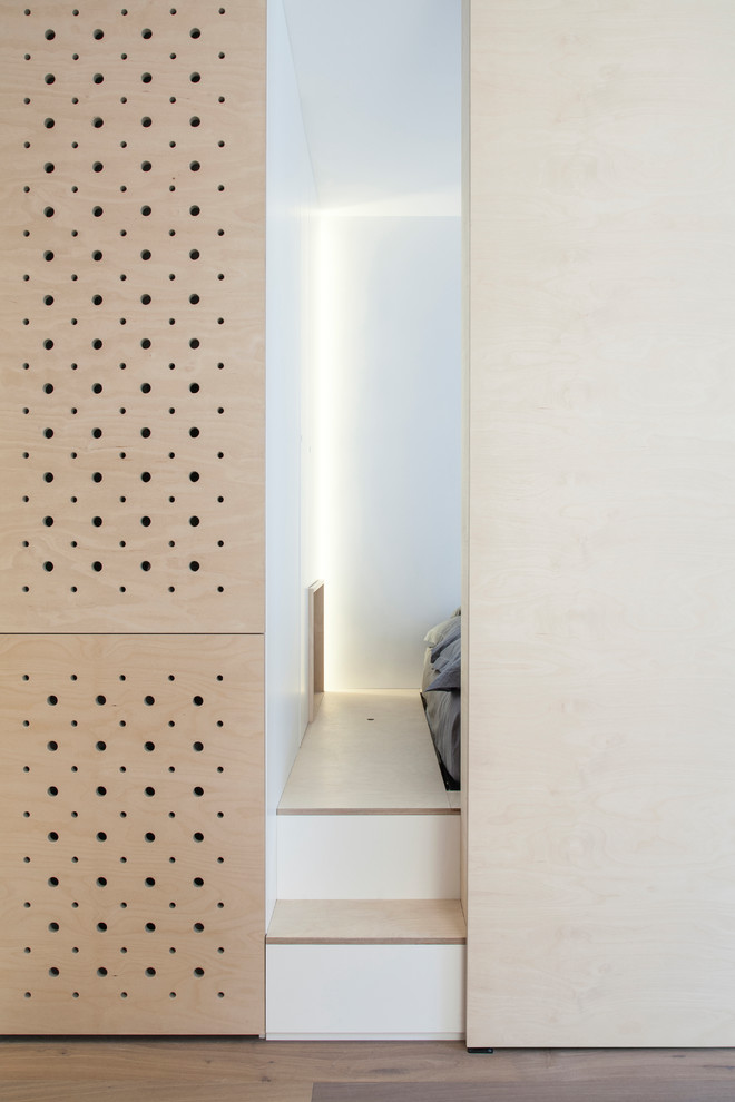 Idées déco pour une chambre parentale blanche et bois scandinave en bois de taille moyenne avec un mur blanc, parquet clair, aucune cheminée et un sol beige.