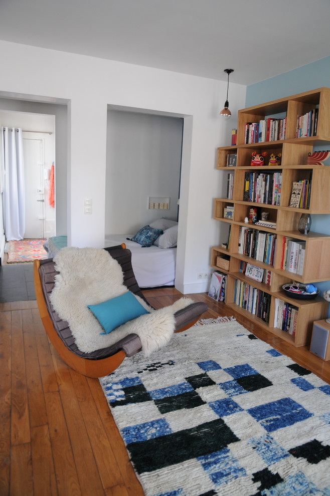 Стильный дизайн: открытая гостиная комната в скандинавском стиле с синими стенами и светлым паркетным полом - последний тренд