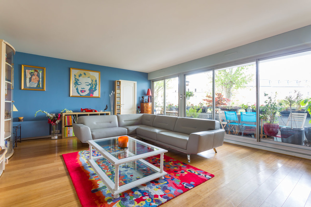 Источник вдохновения для домашнего уюта: большая изолированная гостиная комната в современном стиле с синими стенами, с книжными шкафами и полками и светлым паркетным полом без камина, телевизора