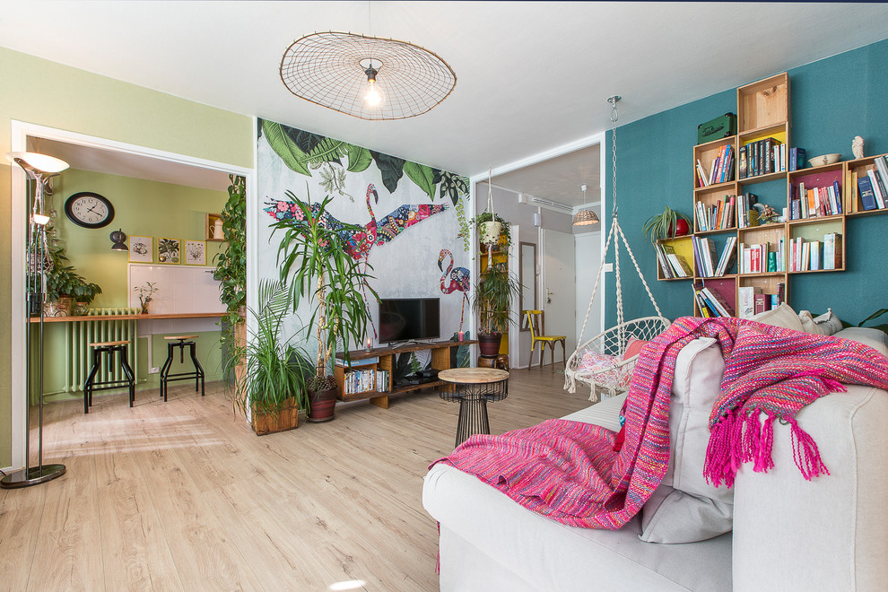 Foto di un soggiorno tropicale di medie dimensioni con pareti multicolore e parquet chiaro