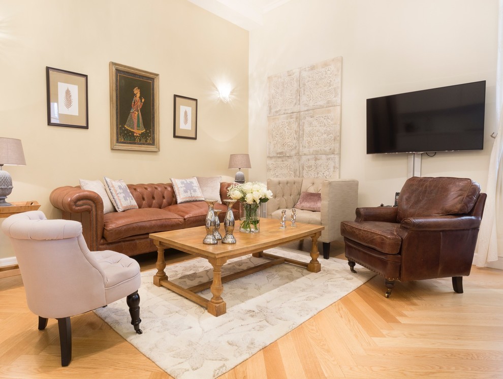 Idee per un soggiorno classico di medie dimensioni con pareti beige, parquet chiaro, TV a parete e pavimento beige
