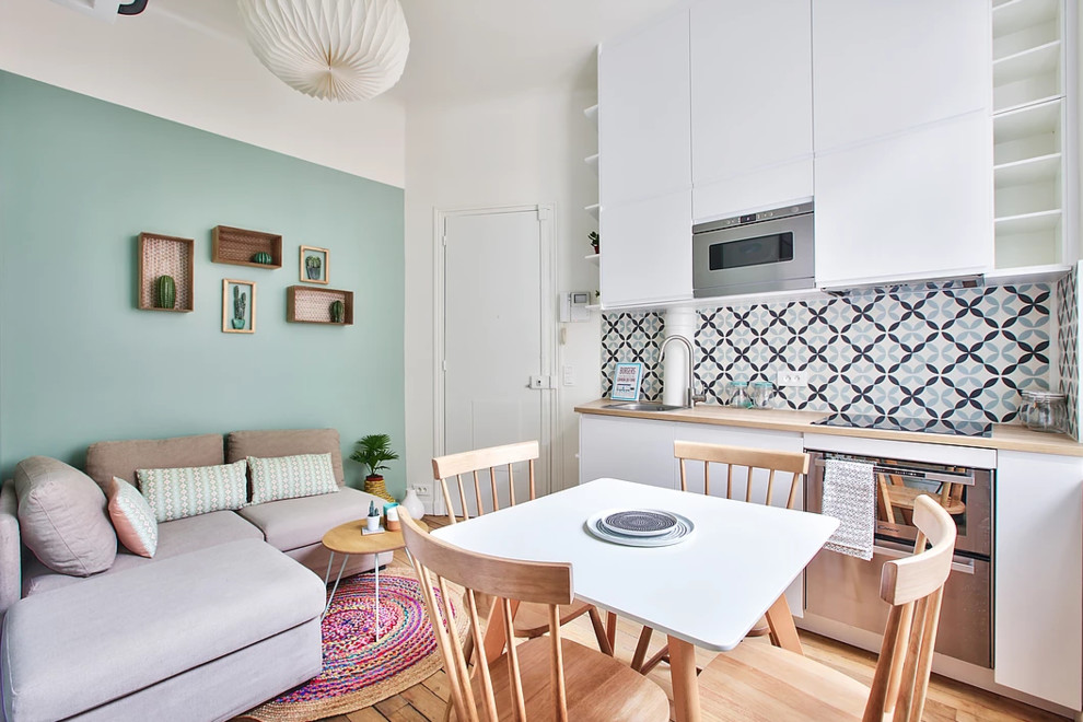 Ispirazione per un piccolo soggiorno scandinavo aperto con pareti verdi, pavimento in legno massello medio, TV a parete e pavimento marrone