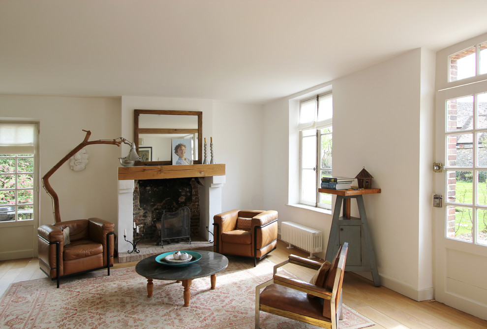 Large cottage open concept light wood floor living room photo in Paris with white walls, a standard fireplace and no tv