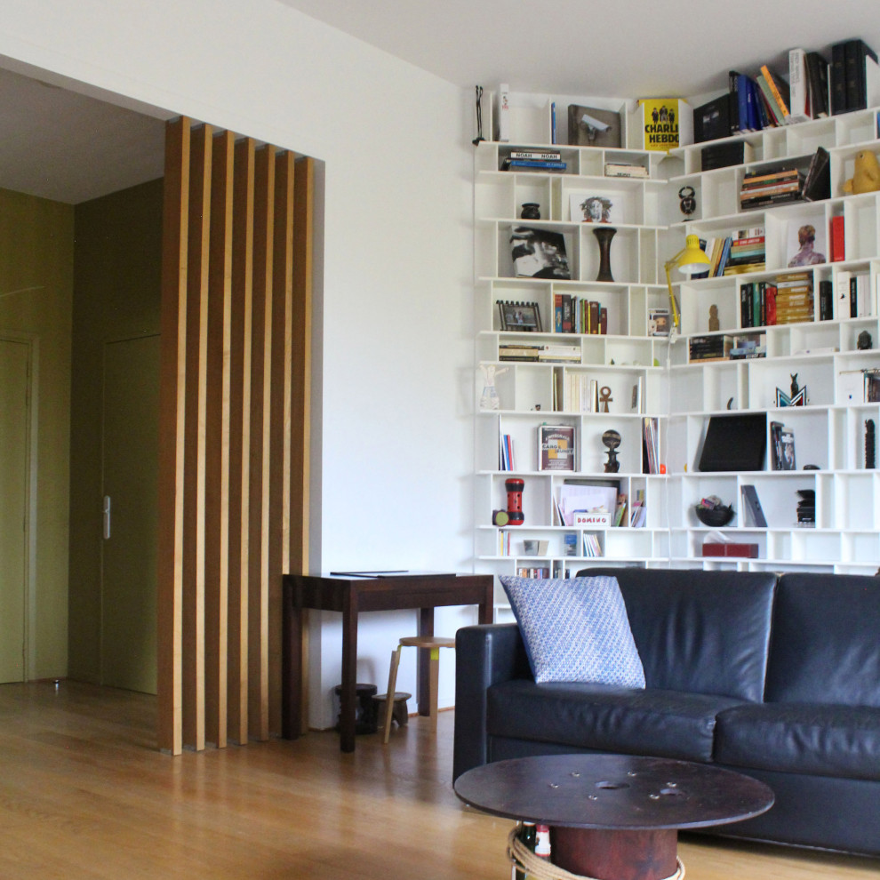 Modelo de biblioteca en casa abierta contemporánea grande sin chimenea y televisor con paredes azules y suelo de madera clara