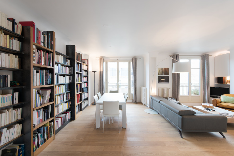 Cette image montre un salon design avec un mur blanc, parquet clair, un sol beige et éclairage.