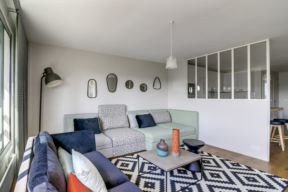 Cette photo montre un salon tendance de taille moyenne et ouvert avec un mur beige, parquet clair, aucune cheminée et un téléviseur indépendant.