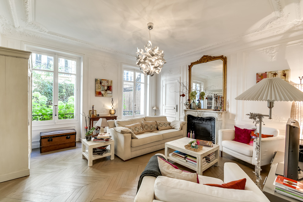 Großes, Offenes Klassisches Wohnzimmer mit weißer Wandfarbe, gebeiztem Holzboden, Kamin, Kaminumrandung aus Stein und freistehendem TV in Paris