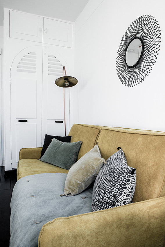 Пример оригинального дизайна: гостиная комната в скандинавском стиле с белыми стенами и горчичным диваном