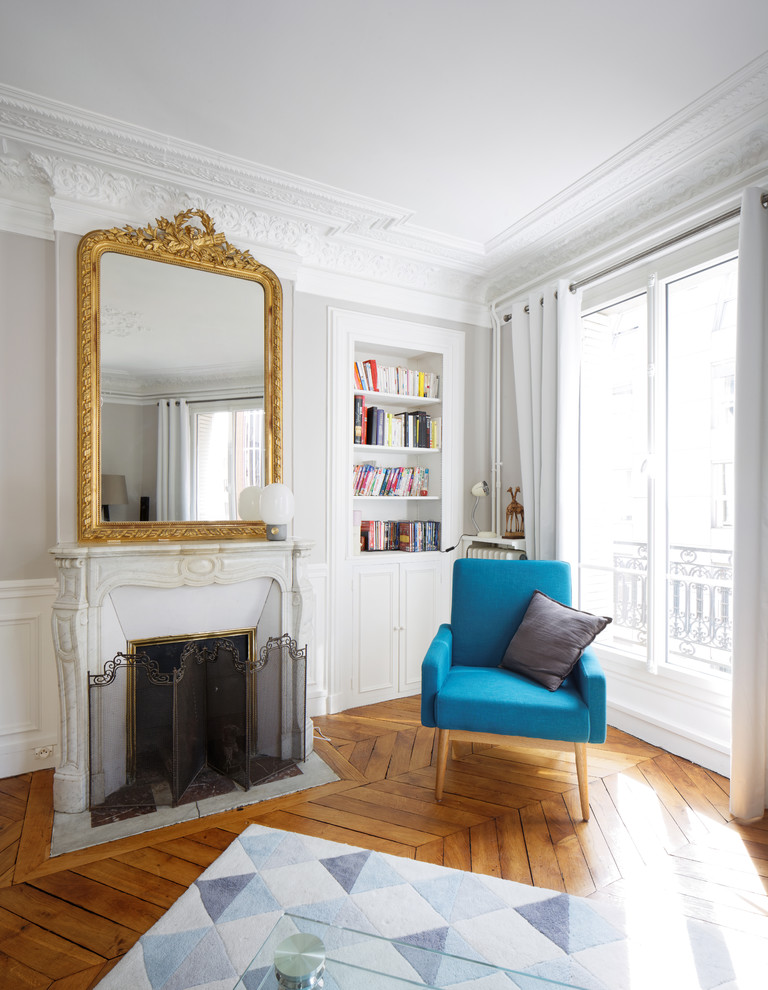 Großes, Repräsentatives Modernes Wohnzimmer mit grauer Wandfarbe, hellem Holzboden, Kamin, Kaminumrandung aus Stein und freistehendem TV in Paris
