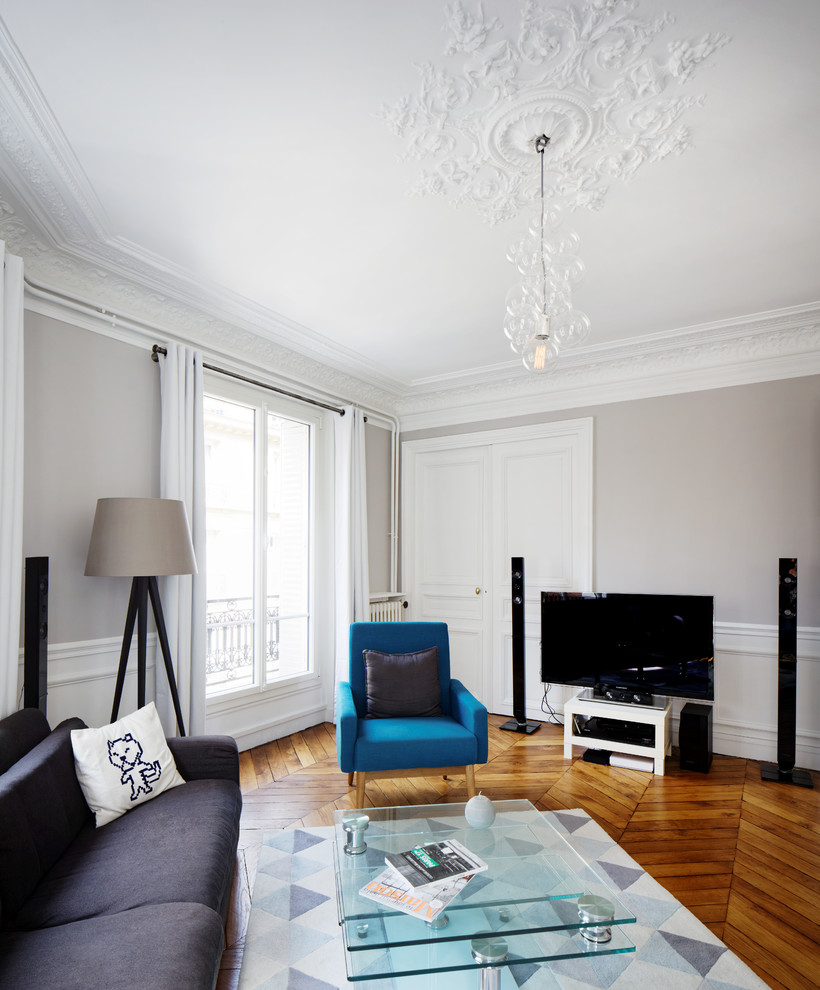 Example of a large trendy formal light wood floor living room design in Paris with gray walls, a standard fireplace, a stone fireplace and a tv stand