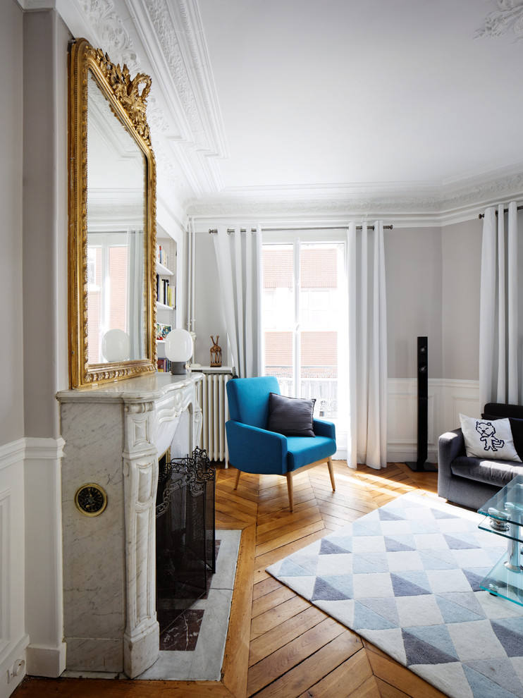 Inspiration for a large contemporary formal living room in Paris with grey walls, light hardwood flooring, a standard fireplace, a stone fireplace surround and a freestanding tv.