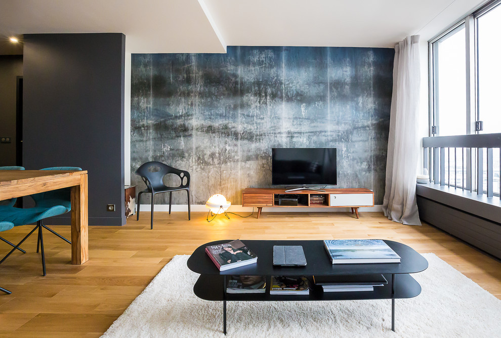 Mittelgroßes, Offenes Modernes Wohnzimmer ohne Kamin mit hellem Holzboden, grauer Wandfarbe und freistehendem TV in Paris