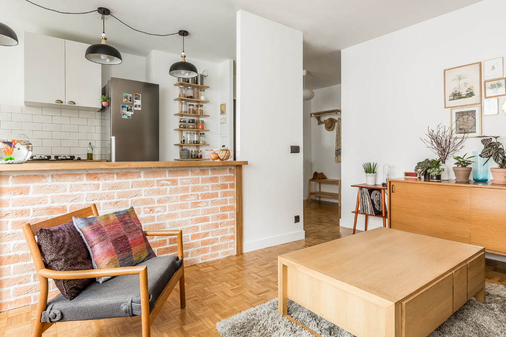 Cette photo montre un salon scandinave ouvert et de taille moyenne avec parquet clair, un mur blanc et un sol marron.