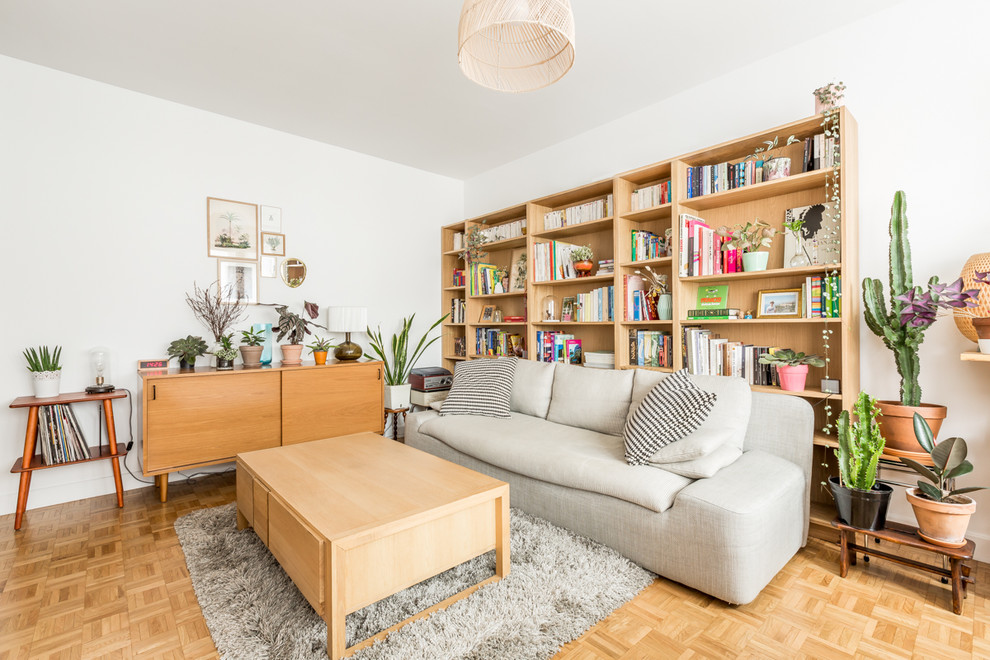 Design ideas for a scandi open plan living room in Paris with light hardwood flooring, a reading nook, white walls and brown floors.