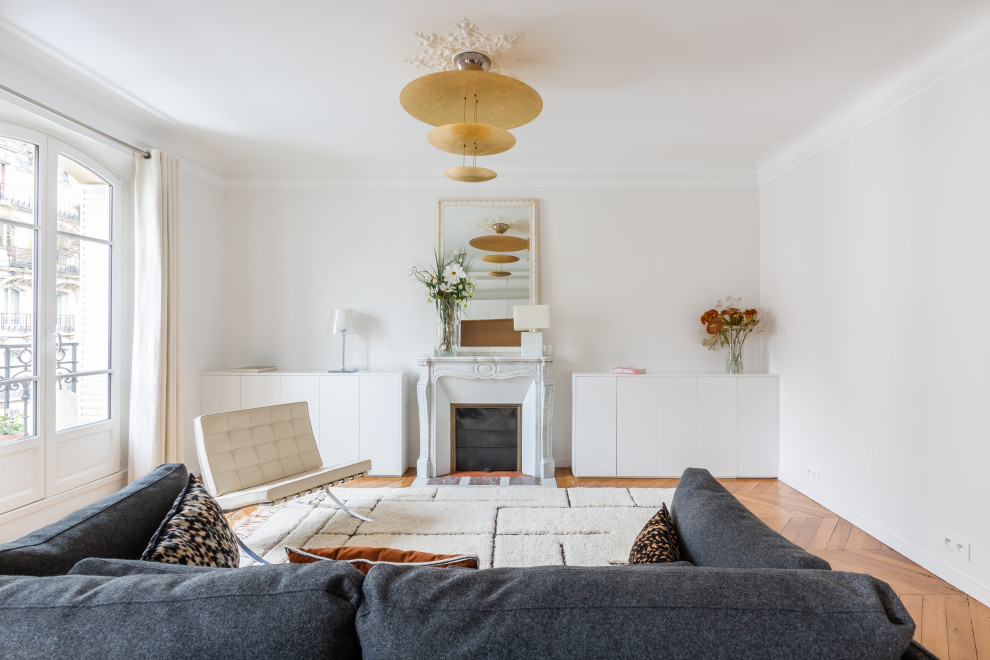Inspiration pour un salon design avec un mur blanc, un sol en bois brun, une cheminée standard et un sol marron.