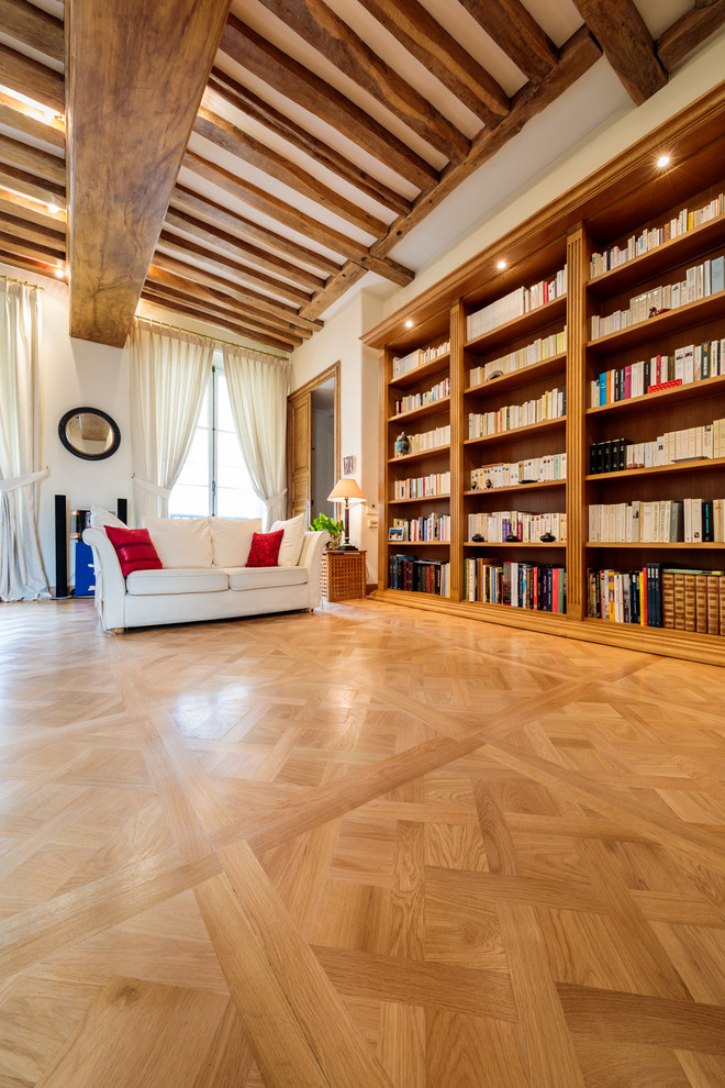 Diseño de biblioteca en casa tradicional renovada con paredes blancas y suelo de madera clara