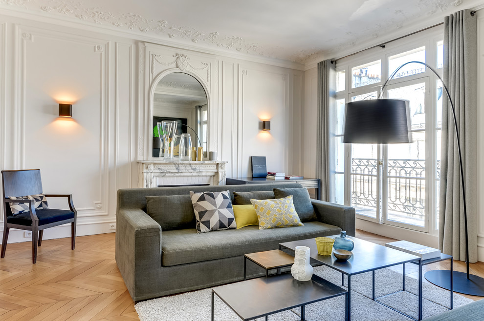Großes, Fernseherloses, Abgetrenntes Modernes Wohnzimmer mit weißer Wandfarbe, braunem Holzboden, Kamin und Kaminumrandung aus Stein in Paris