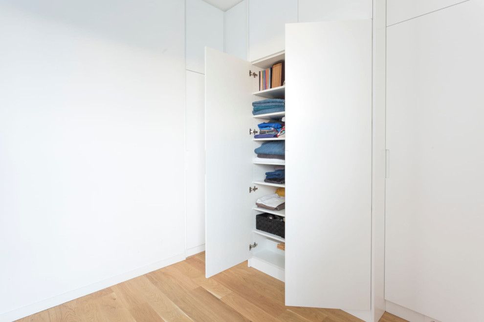 Cette image montre une chambre design de taille moyenne avec un mur blanc, parquet clair et aucune cheminée.
