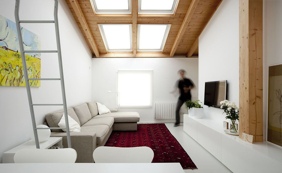 Пример оригинального дизайна: двухуровневая гостиная комната среднего размера в стиле модернизм с с книжными шкафами и полками, белыми стенами, бетонным полом, серым полом и телевизором на стене без камина