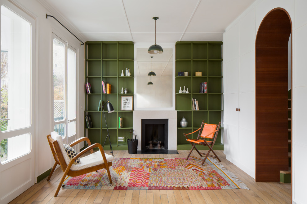 Immagine di un soggiorno minimal aperto con pareti bianche, pavimento in legno massello medio, camino classico e pavimento marrone