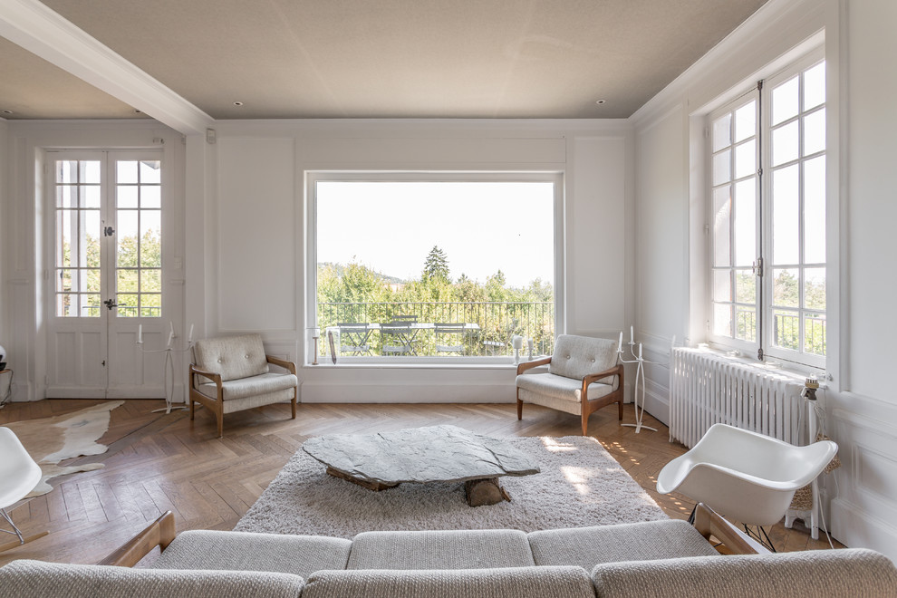 Imagen de salón para visitas abierto tradicional renovado grande sin chimenea y televisor con paredes blancas y suelo de madera en tonos medios