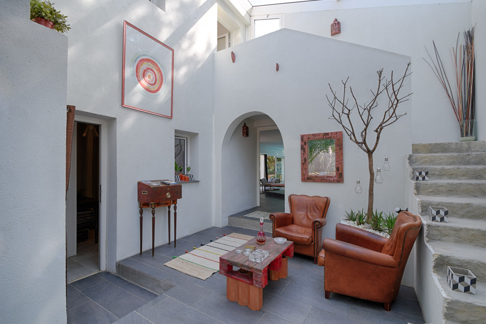 Mittelgroßes, Fernseherloses, Offenes Mediterranes Wohnzimmer ohne Kamin mit weißer Wandfarbe und Keramikboden in Marseille