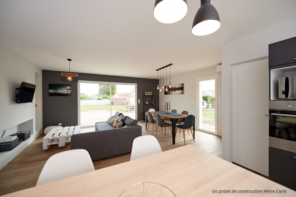 This is an example of a medium sized urban open plan living room in Bordeaux with grey walls, terracotta flooring, no fireplace, a wall mounted tv and brown floors.