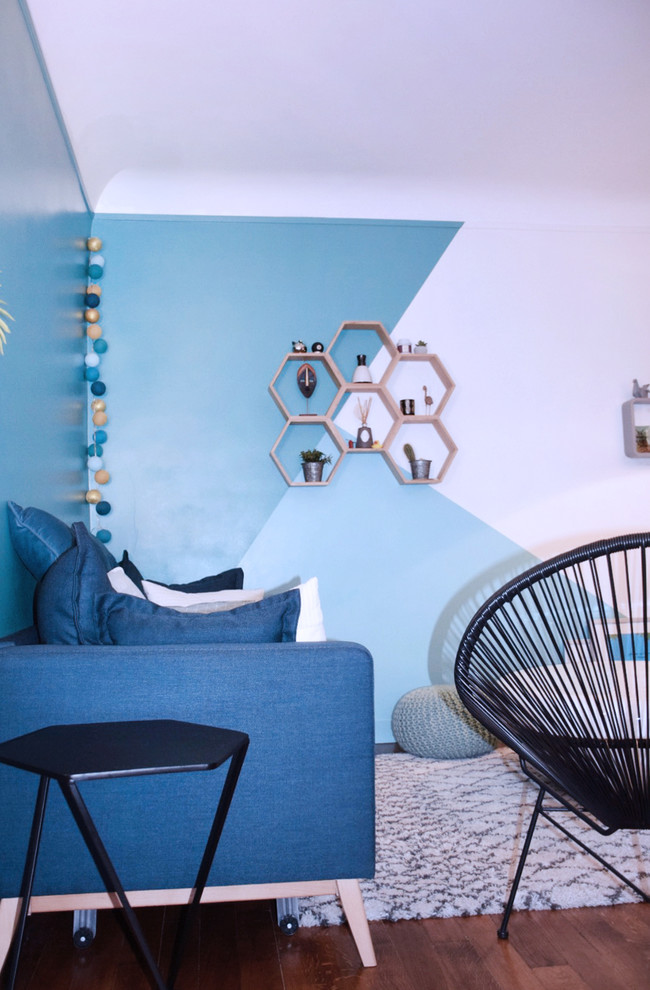 Kleines, Offenes Modernes Wohnzimmer ohne Kamin mit blauer Wandfarbe, braunem Holzboden, freistehendem TV und braunem Boden in Paris