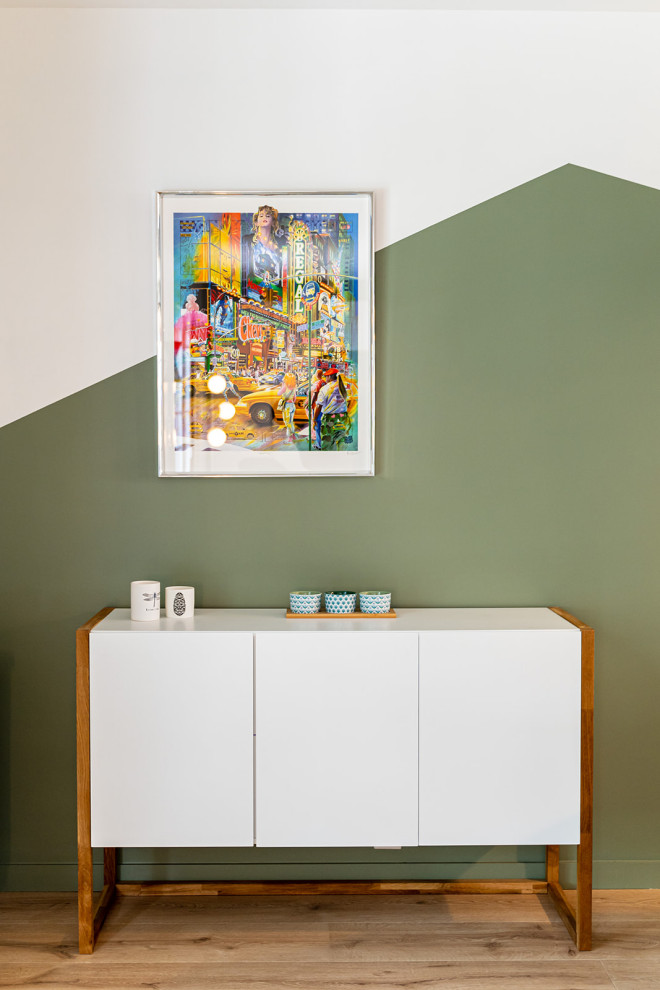 Foto de salón abierto nórdico grande con paredes verdes, suelo de madera clara, estufa de leña y pared multimedia