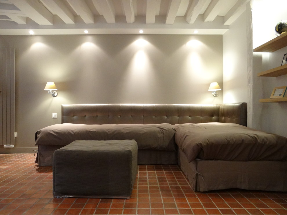 Modern inredning av ett litet vardagsrum, med beige väggar och klinkergolv i terrakotta