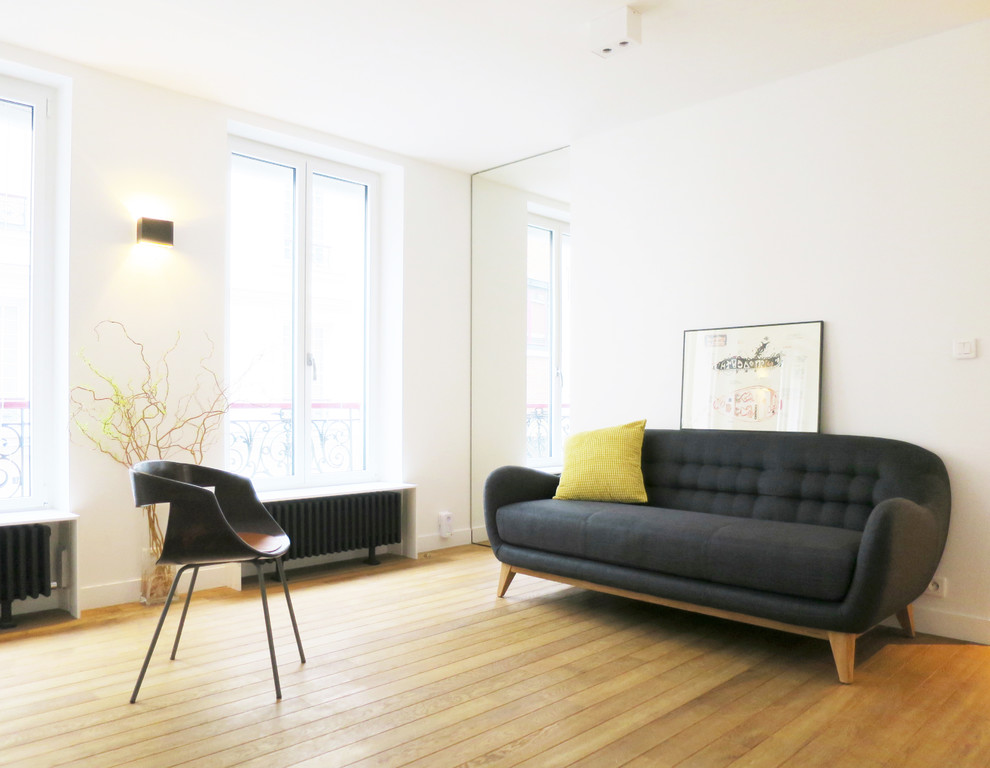 Immagine di un soggiorno scandinavo aperto e di medie dimensioni con pareti bianche, pavimento in legno massello medio, nessun camino e nessuna TV