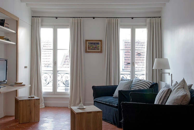 Aménagement d'un salon classique de taille moyenne avec un mur beige, tomettes au sol, un téléviseur indépendant et un sol orange.