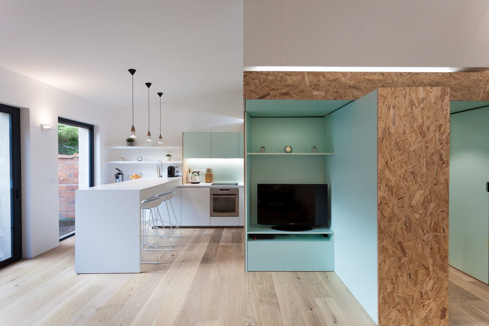 Ispirazione per un piccolo soggiorno scandinavo aperto con pareti verdi, pavimento in legno massello medio e TV nascosta