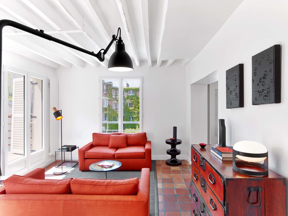パリにある高級な中くらいなコンテンポラリースタイルのおしゃれなリビング (白い壁、テラコッタタイルの床、暖炉なし、テレビなし、赤いソファ) の写真