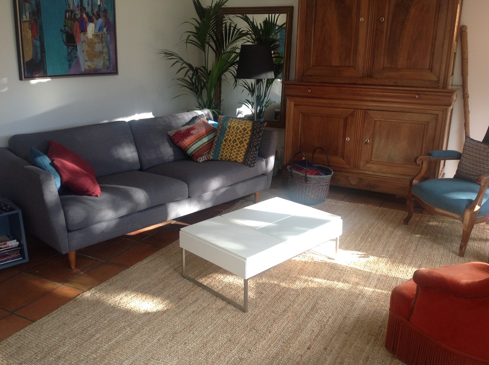 Foto di un soggiorno chic di medie dimensioni e chiuso con pareti bianche, pavimento in terracotta, nessun camino e pavimento marrone